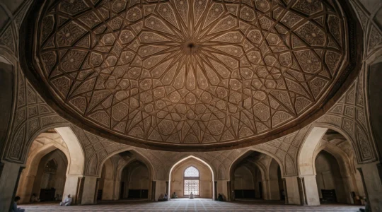 Wide editorial photograph of an intricately carved geometric star pattern inside a domed prayer hall, bathed in soft natural light